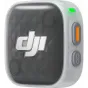 DJI Mic Mini 2S wireless lavalier transmitter in a white case, front view with green LED indicator, orange power button and gray side button, transparent panel showing DJI logo and MINI 2S label.