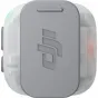 DJI MIC MINI 2S transmitter inside a clear protective case, front view with embossed DJI logo, green power indicator lit, compact wireless lavalier microphone.