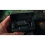 GoPro Wireless Mic Complete Kit open case with two clippable transmitters, central control unit with power button and gain knob, USB-C and 3.5 mm receivers, and charging case held in hand