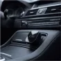 Беспроводной адаптер Tech-Protect CA01 для CarPlay/Android Auto установлен в центральной консоли автомобиля с кожаной отделкой, с элегантным черным дизайном и логотипом бренда.