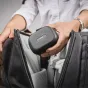 Rode Wireless GO Charge Case+ compact black textured charging case held in hand while opening a dark gray bag