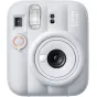 Фронтальный вид керамически белого Fujifilm Instax Mini 13 instant camera с большим круглыми объективом, встроенной вспышкой, кнопкой self-timer с оранжевым кольцом, видоискателем и названием модели в правом верхнем углу.