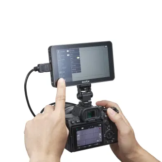 Godox GM6S Pro 4K Ultra Bright 5.5" camera monitor attached to a mirrorless camera, showing live view and menu, with HDMI cable connected, highlighting its 2000-nit ultra-bright touchscreen and professional video monitoring capa
