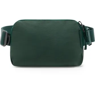 Peak Design City Sling 2L cyprus zilsā sling bag ar iespējamo joslām, zelta metalu klikšķēm un frontālajai zipper pēdē, parādīts frontā uz baltu laukā.