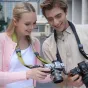 Leofoto L‑CS‑207 black camera strap with quick‑attach ball system and 360° lock, worn by a woman and a man each holding a camera, highlighting comfortable microfiber and three carrying options.